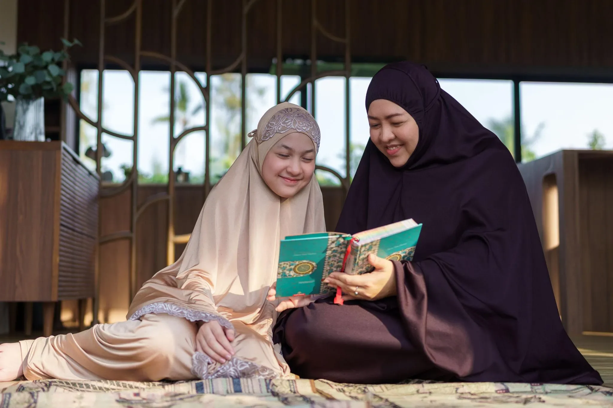 Seorang ibu muslimah sedang membersamai dan mendidik anaknya dengan penuh kasih sayang