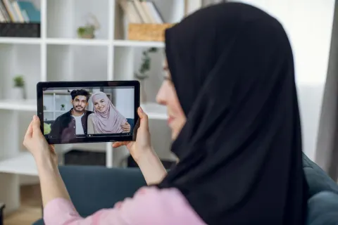 Seorang Muslimah menjalin silaturahmi dengan keluarga melalui telepon dari rumah